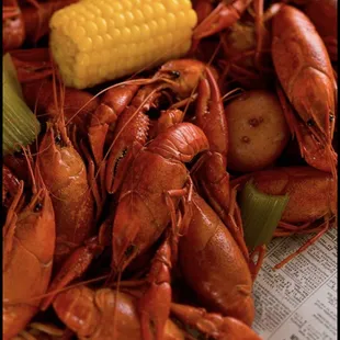 a pile of craws, corn, and potatoes