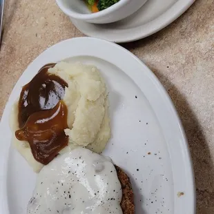 Country fried steak, mashed potatoes, mixed vegetables .   Mom&apos;s pancakes off to the side.