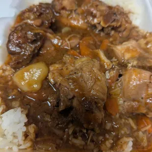 Brown stewed chicken served with at least day old rice