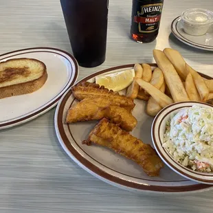 two plates of fish and fries and coleslaw