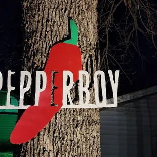 a sign on a tree in front of a house