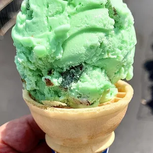 a hand holding a cone of ice cream