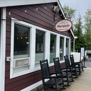 a row of rocking chairs outside a restaurant