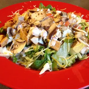 a red plate with a salad on it
