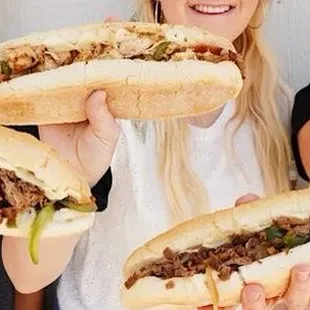 three women holding sandwiches