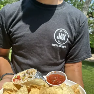 a man holding a plate of nachos