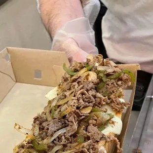 a man holding a sandwich in a box