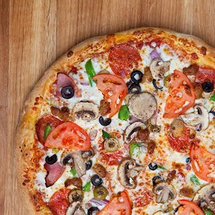 a pizza with tomatoes, mushrooms, and olives