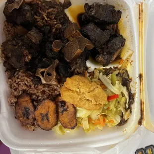 Large oxtail with rice and beans, cabbage and plantains