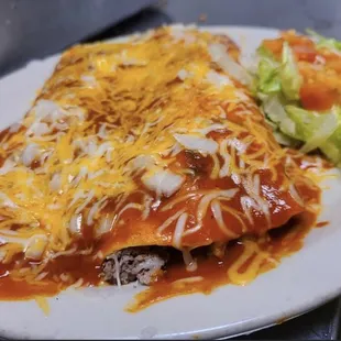 Smothered ground beef burrito topped with onions and red enchilada sauce