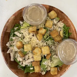 a bowl of salad with croutons and dressing