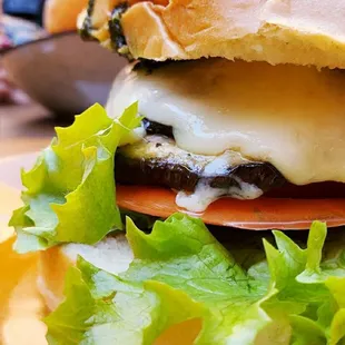 a cheeseburger with lettuce and tomato