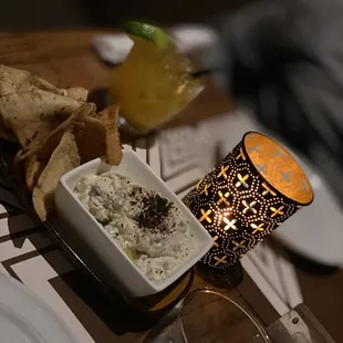 a bowl of dip and chips on a table