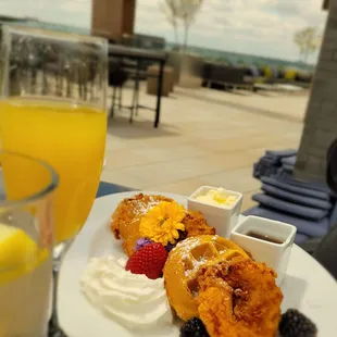 a plate of food and a glass of orange juice