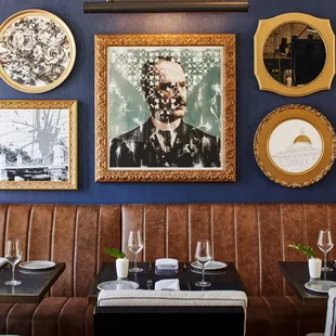 a dining room with blue walls and brown leather booths