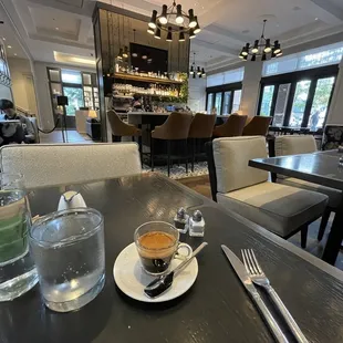 a cup of coffee and a glass of water on a table