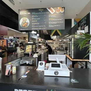 a restaurant with a counter and a menu on the wall