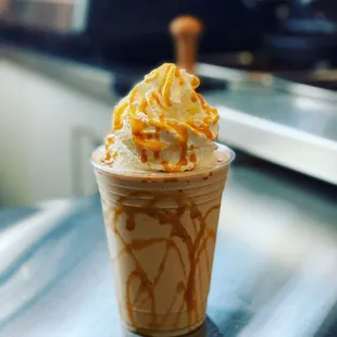 a cup of coffee with whipped cream and caramel