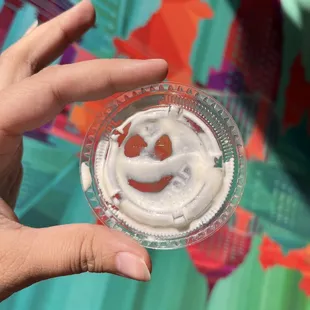 a hand holding a cup of yogurt
