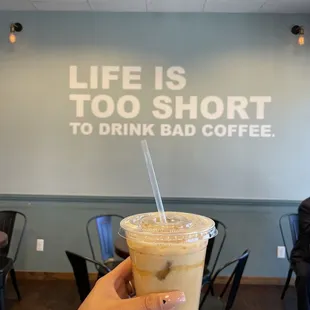 a hand holding a cup of iced coffee
