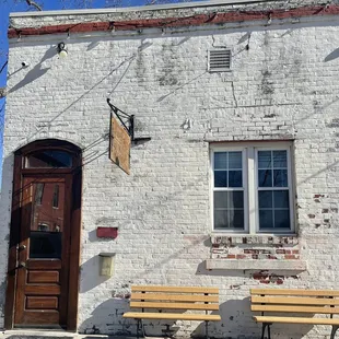 two benches in front of a brick building