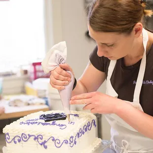 a woman decorating a cake