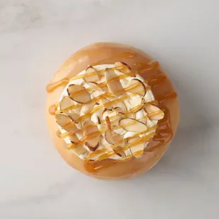 Salted Caramel Crème Doughnut - Glazed doughnut topped with vanilla glaze, roasted almonds and caramel sauce.