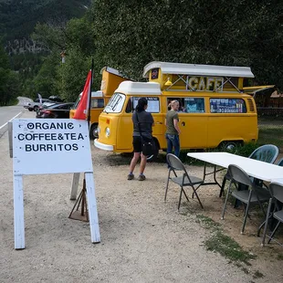 a yellow van with a sign that says organic coffee and tea burritos