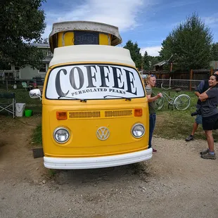 two people standing in front of a coffee van