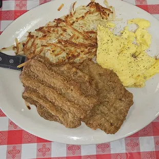Counrty fried steak, hasbrowns and scrambled eggs.