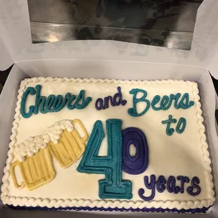 a cake in a box with the words cheers and beers written on it