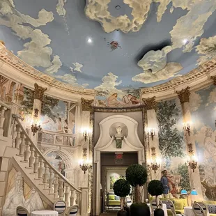 a room with a sky painted on the ceiling