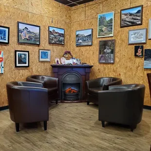 a lounge area with chairs and a fireplace