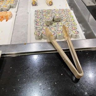 a variety of sushi rolls and chopsticks