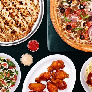 Pictured is our delicious pizza called "The Works", our gooey, cheesy breadsticks, grilled chicken salad, chicken parmesan, wings and dips.