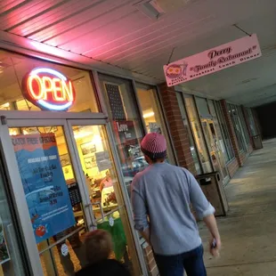 a man and a woman walking in front of the store