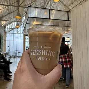 a hand holding a cup of coffee
