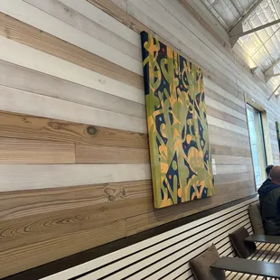 a man sitting on a bench in front of a painting
