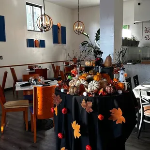 a table with a black tablecloth and pumpkins