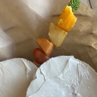 Bagel with cream cheese and fruit kabob.
