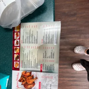a menu and a person's feet