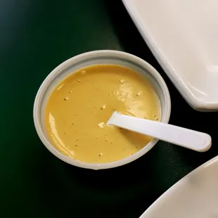 a bowl of sauce with a spoon in it