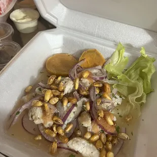 a takeout container with a salad in it