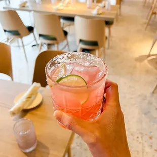 a person holding a cocktail in a restaurant