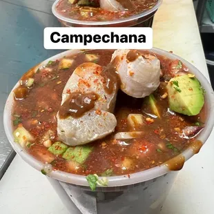 two cups of soup with a side of avocado