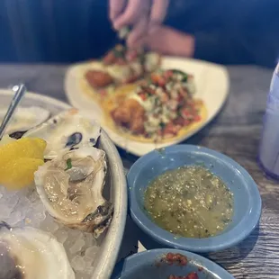 a plate of oysters and a bowl of salsa
