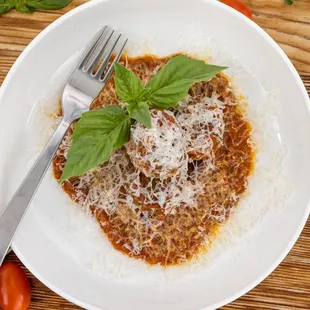 a plate of pasta with basil and tomatoes