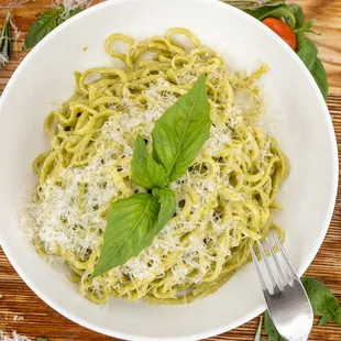 a bowl of spaghetti with basil and parmesan cheese
