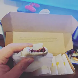 a person holding a sandwich in a box