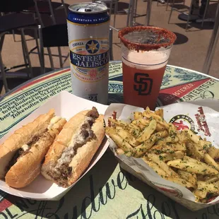 Cheesesteak sandwich with American cheese and garlic fries.